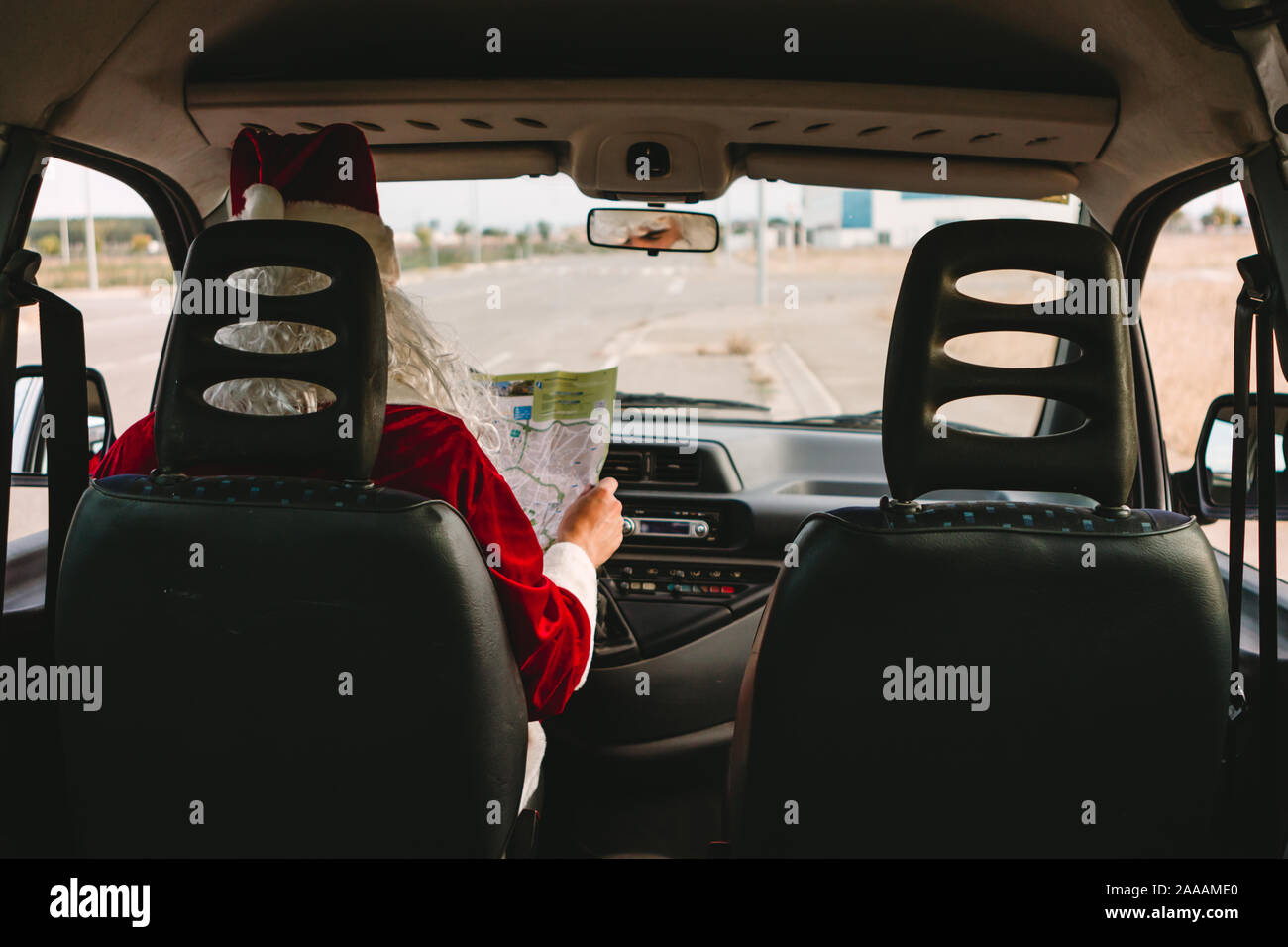 Santa Claus als Delivery Man und Überprüfung einer Karte in einem Auto Stockfoto