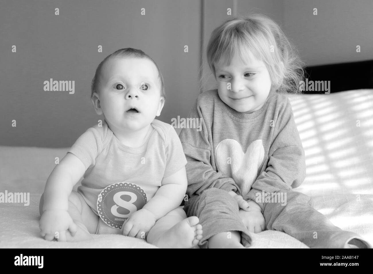 Nahaufnahme, Porträt von zwei Schwestern, 3 Jahre alt Blond Kleinkind Mädchen und 8 Monate altes Baby, Schwestern, beste Freunde, Happy Family Konzept Stockfoto