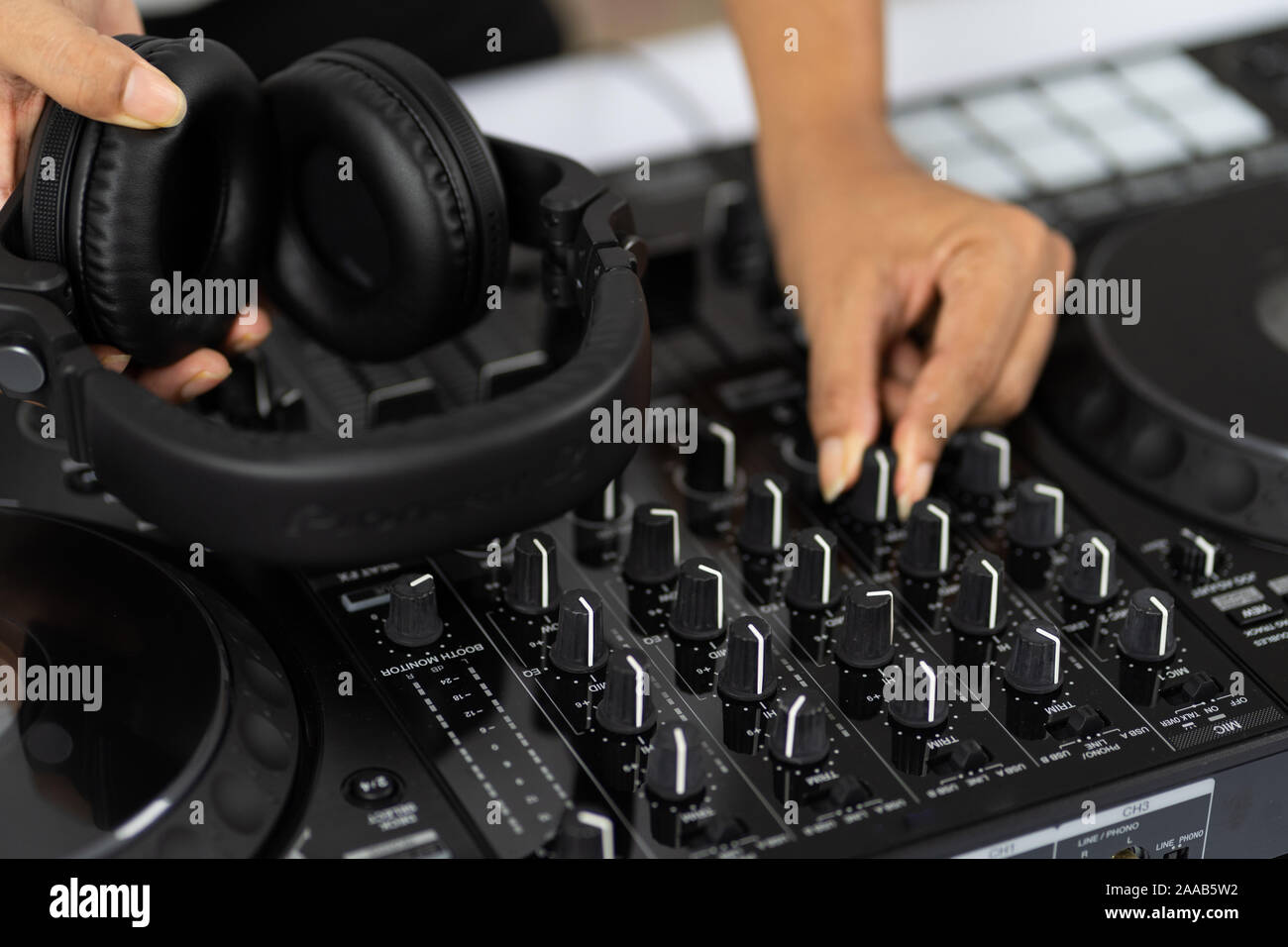 Hände von DJ Mixing Titel auf Professional Sound Mixer. Modische Ringe am Finger des Mädchens Discjockey Musik. Closeup, Knöpfe und Regler in Stockfoto