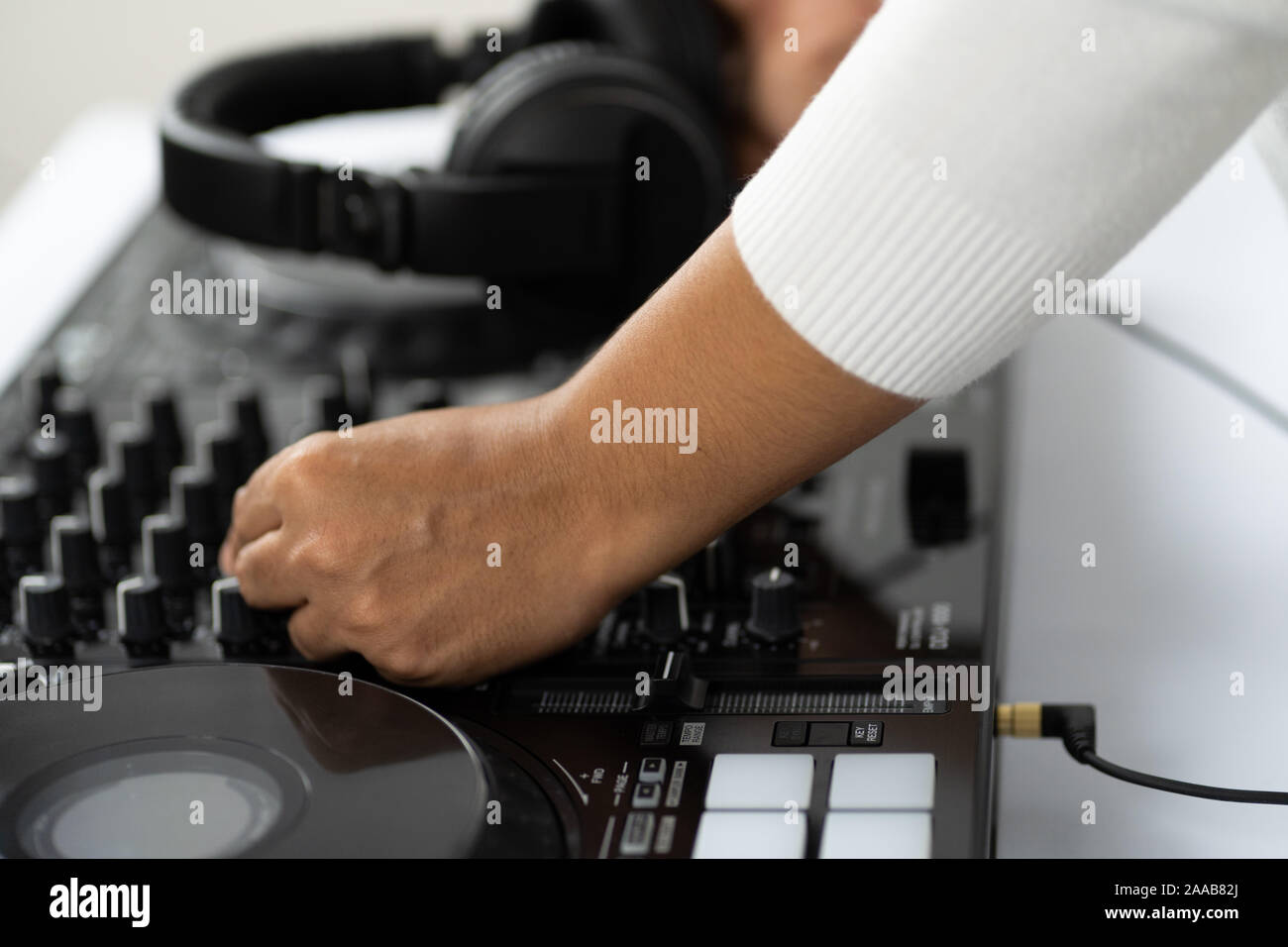 Hände von DJ Mixing Titel auf Professional Sound Mixer. Modische Ringe am Finger des Mädchens Discjockey Musik. Closeup, Knöpfe und Regler in Stockfoto