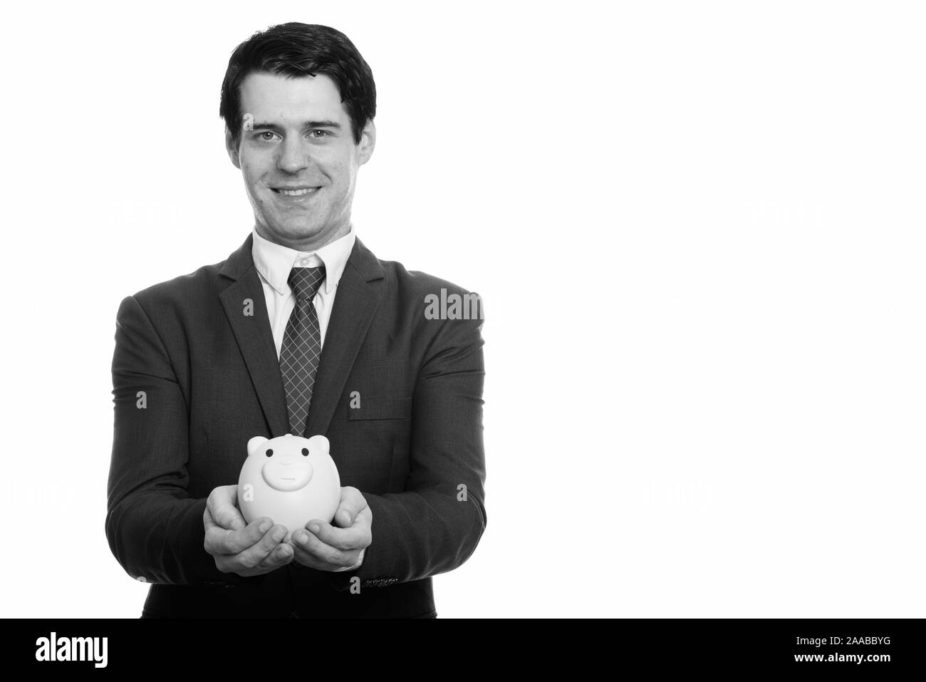 Studio geschossen von glücklich, Geschäftsmann, Lächeln, während Sie piggy Bank Stockfoto