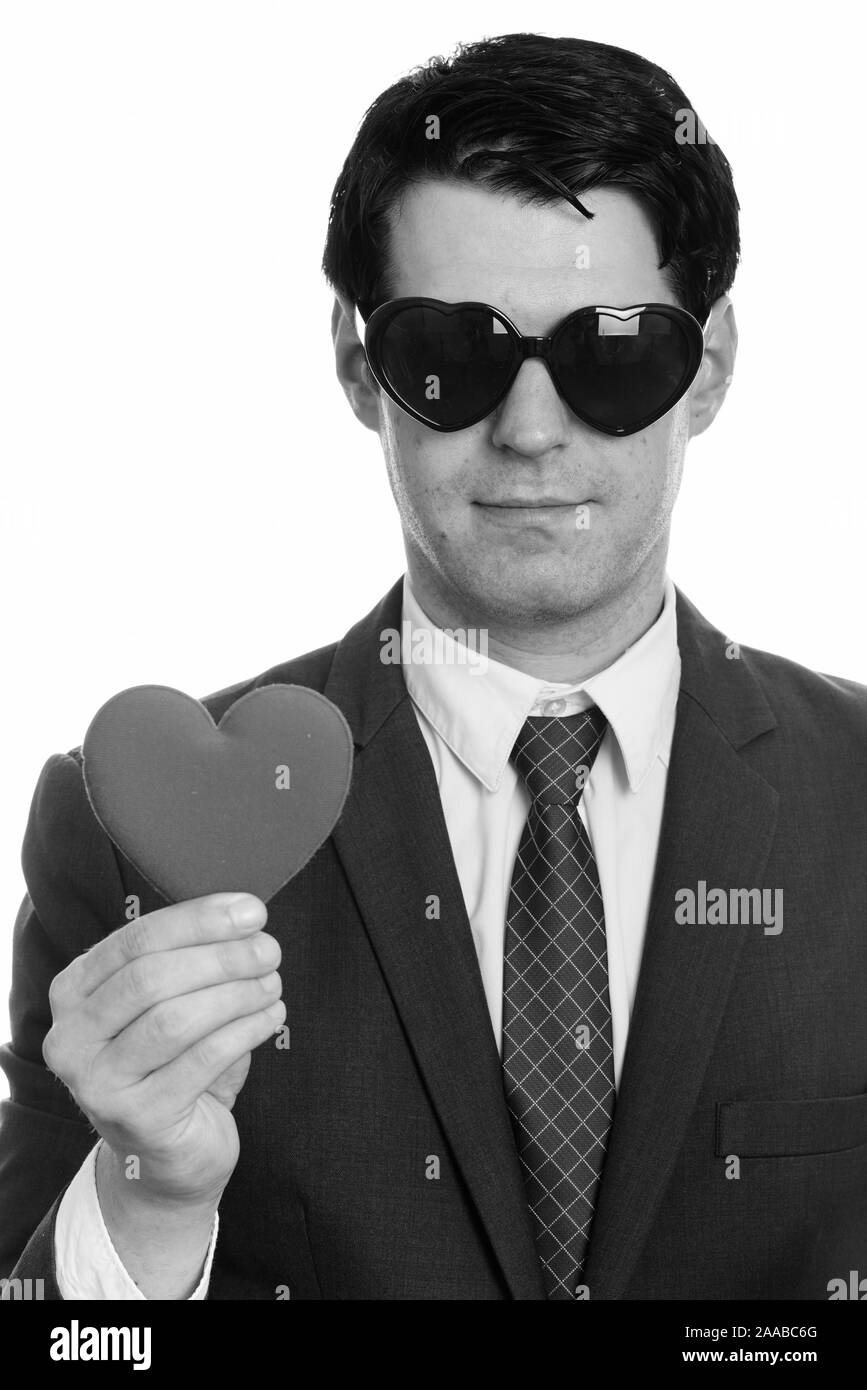 Gut aussehender Geschäftsmann, tragen, Sonnenbrille Herzform während halten roten Herzen Stockfoto