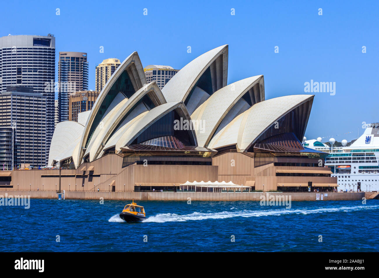 Sydney, Australien - 19. Dezember 2013: ein Wassertaxi Geschwindigkeiten hinter dem Opernhaus in Sydney. Das Gebäude ist in der ganzen Welt berühmt. Stockfoto