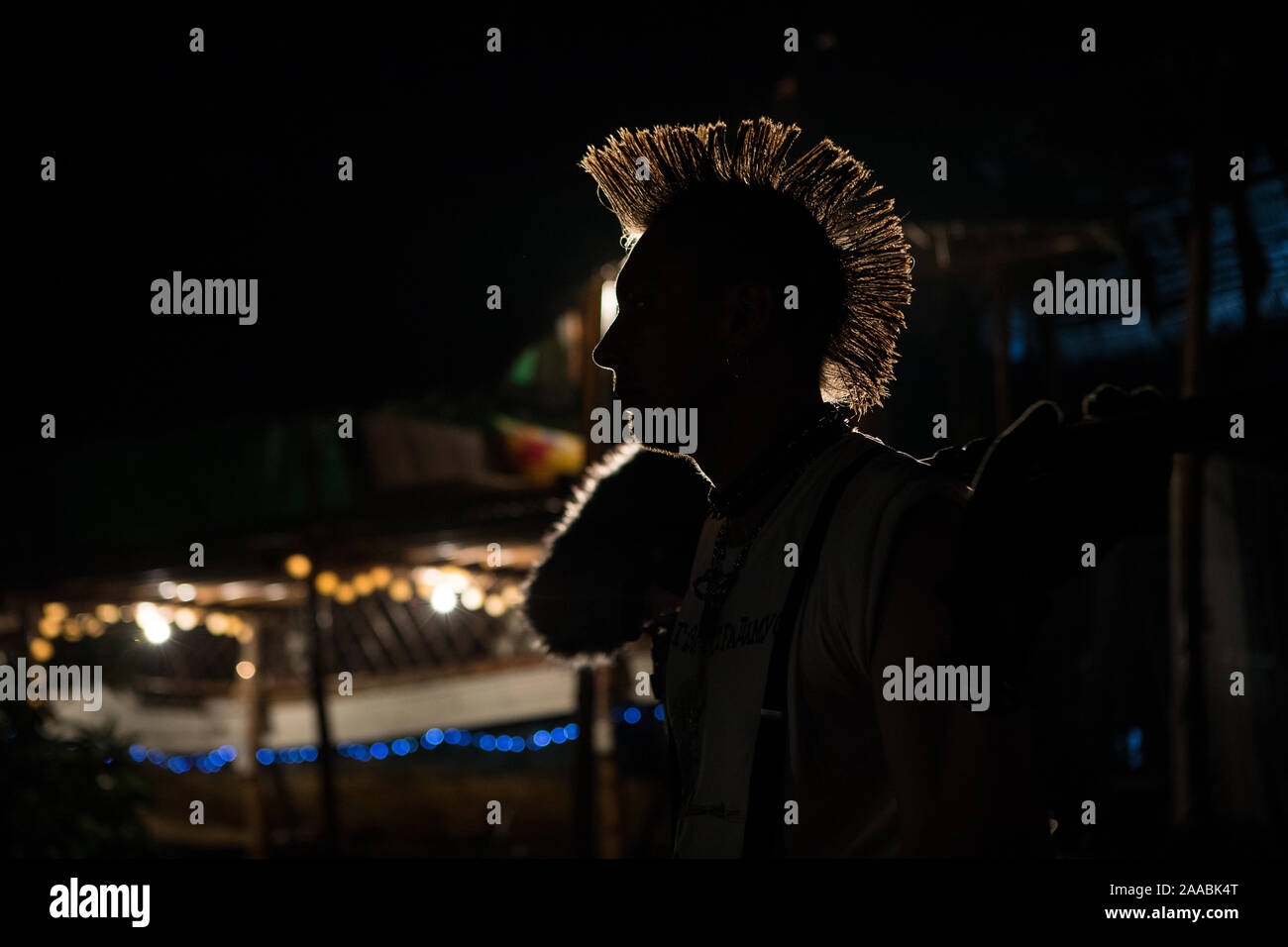 Silhouette einer Punk mit einem Mohawk in der Dunkelheit im Hintergrund Licht, Nacht Musik Party Stockfoto