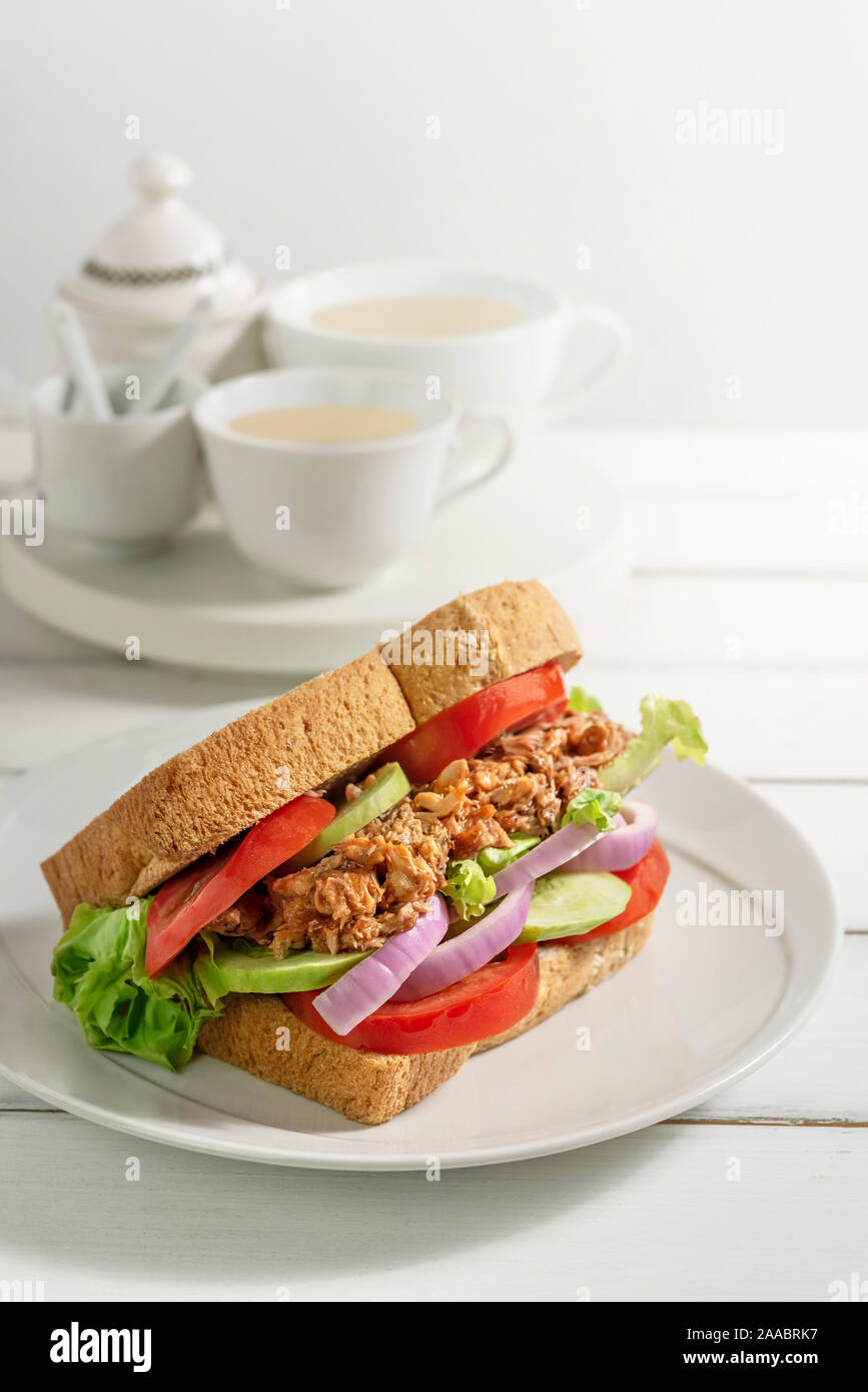 Close up getoastetes Sandwich mit Fisch und frisches Gemüse auf Teller Stockfoto
