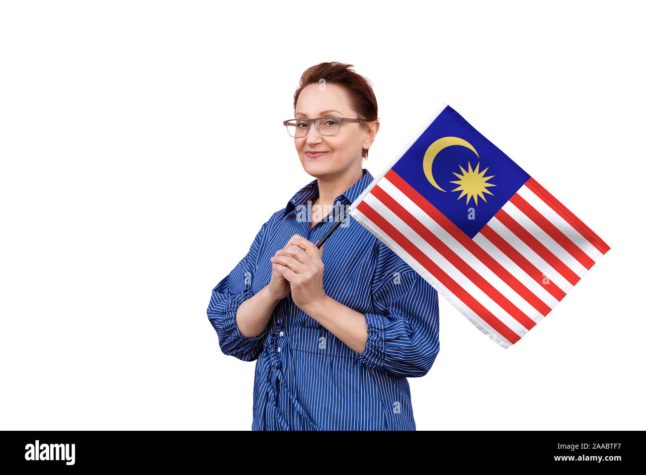 Malaysia Fahne. Frau mit malaysischer Flagge. Schönes Portrait der Dame im mittleren Alter 40 50 Jahre alt, eine große Flagge mit weissem Hintergrund. Stockfoto