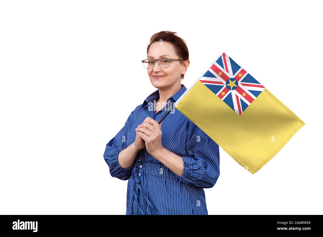 Niue Flagge. Frau mit Flagge. Schönes Portrait der Dame im mittleren Alter 40 50 Jahre alt, eine große Flagge mit weissem Hintergrund. Stockfoto