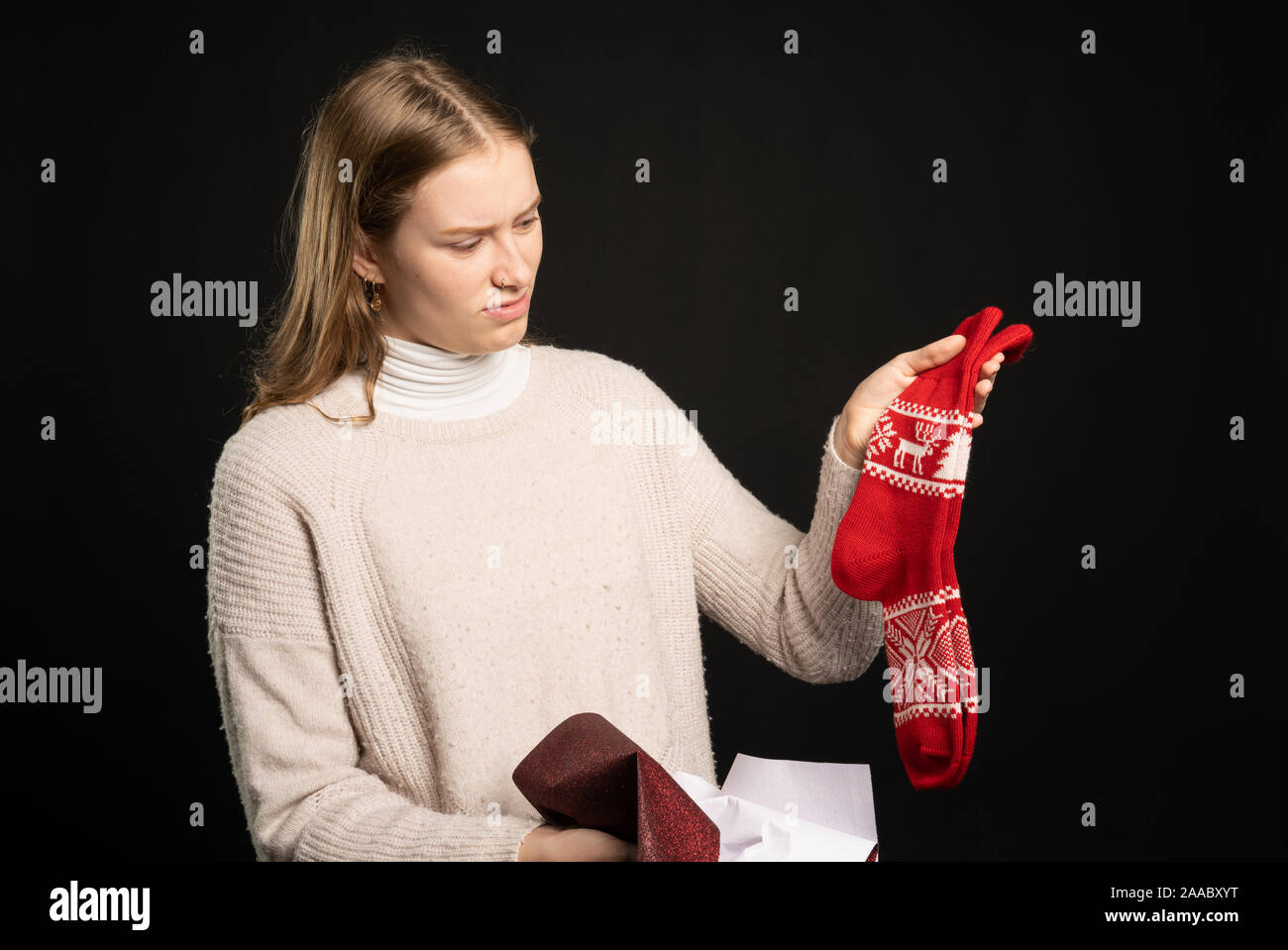 Ein enttäuschter junge Frau hält Ihr Geschenk Socken Stockfoto