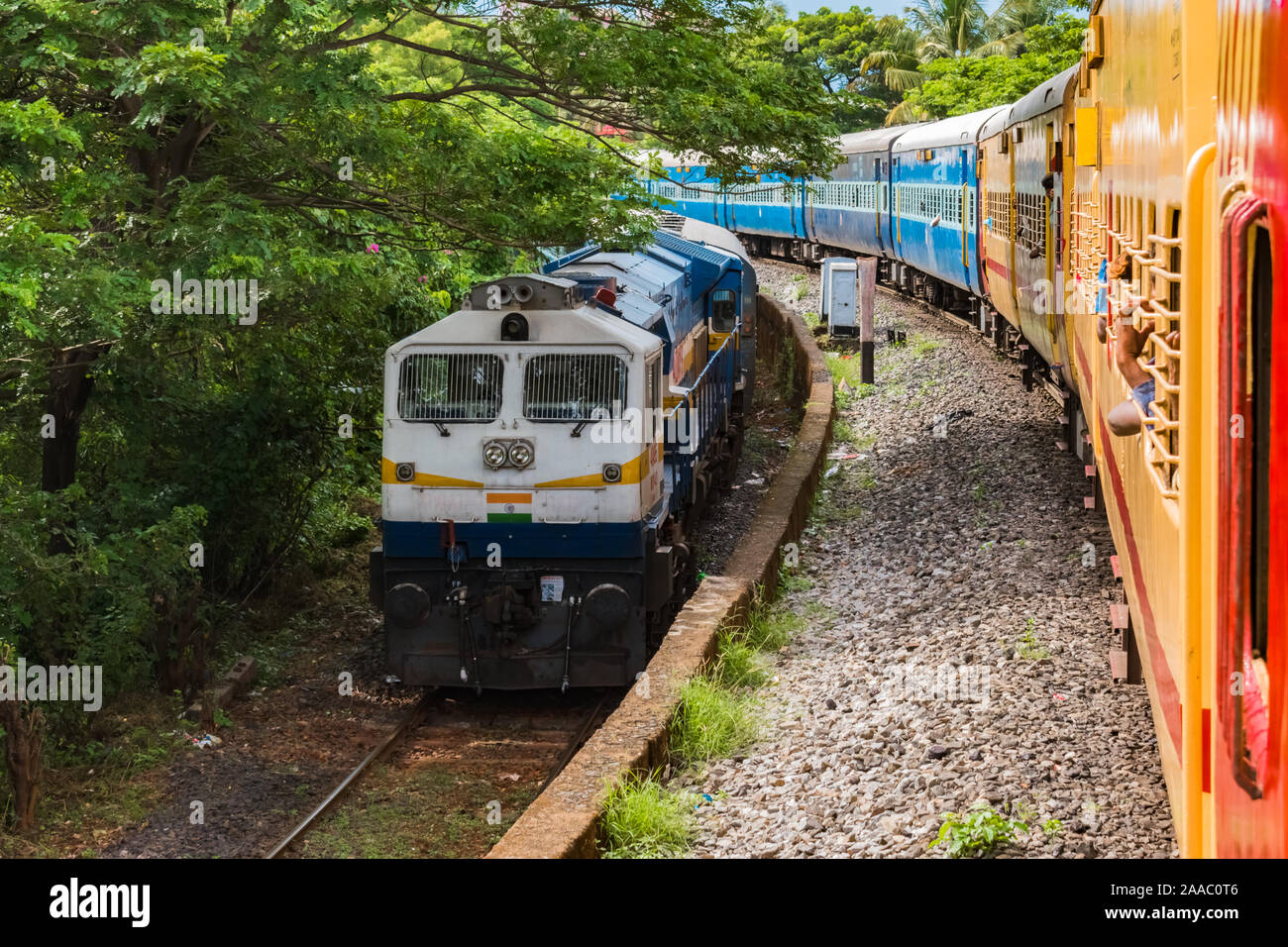 Zwei Züge der indischen Eisenbahn parallel in entgegengesetzte Richtungen kreuzen zu langsam sind, inmitten einer hügeligen Gebiet der Western Ghats. - Bild Stockfoto