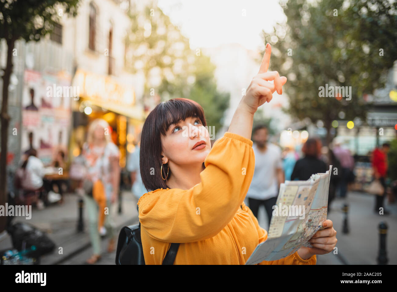 Schöne junge Mädchen in modische Kleidung mit Karte Spaziergänge durch die Stadt und sieht sich um. Traveler Konzept Bild Stockfoto