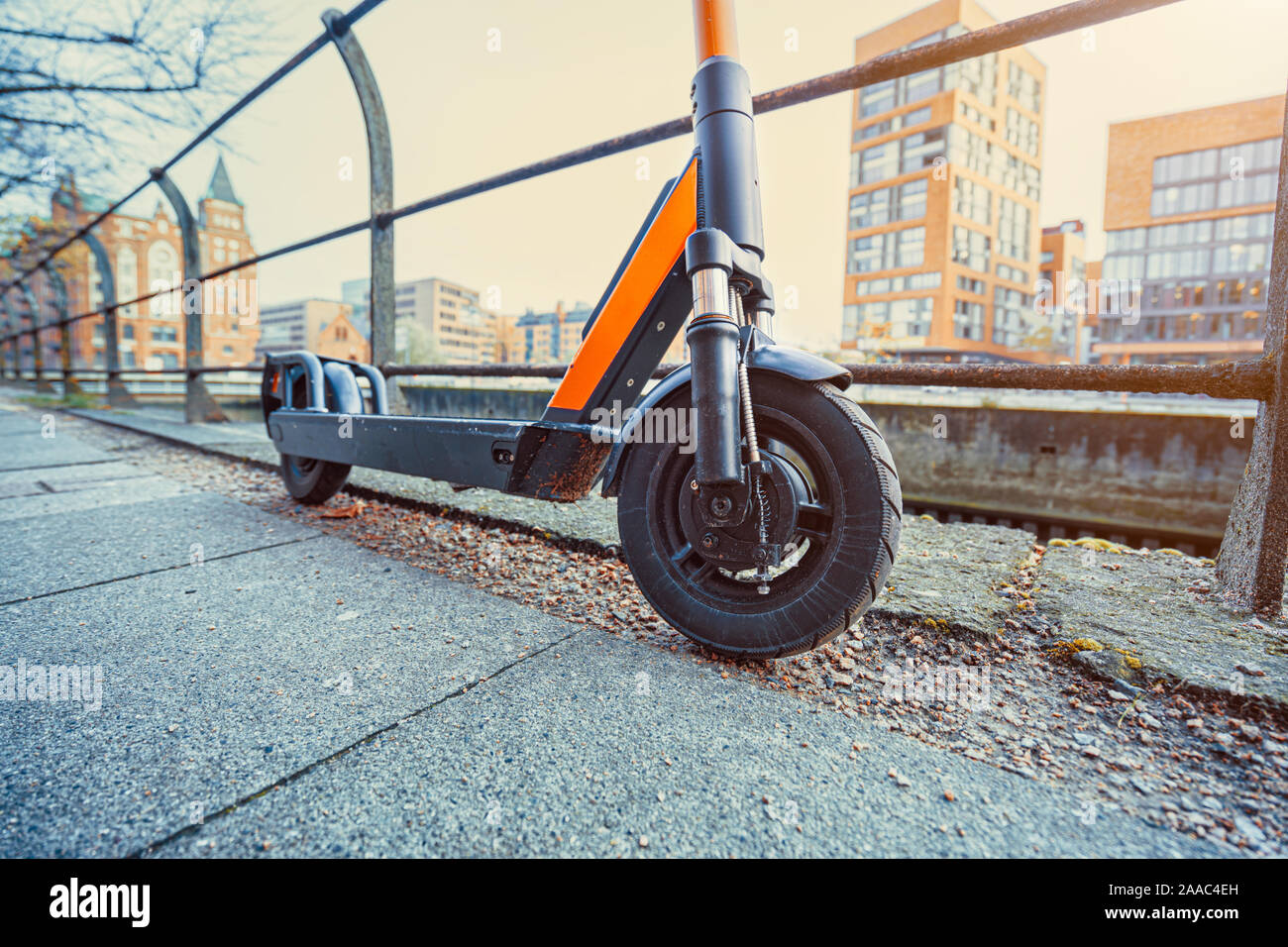 Orange e-Scooter vorne perspektivische Ansicht geparkt im Freien am Gehsteig der Stadt Szene. Stockfoto