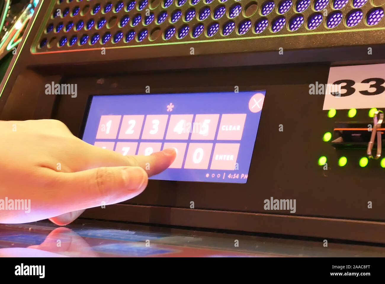 Bewegung von Menschen mit PIN-Nummer auf Slot Machine für Geld einlösen im Casino Stockfoto