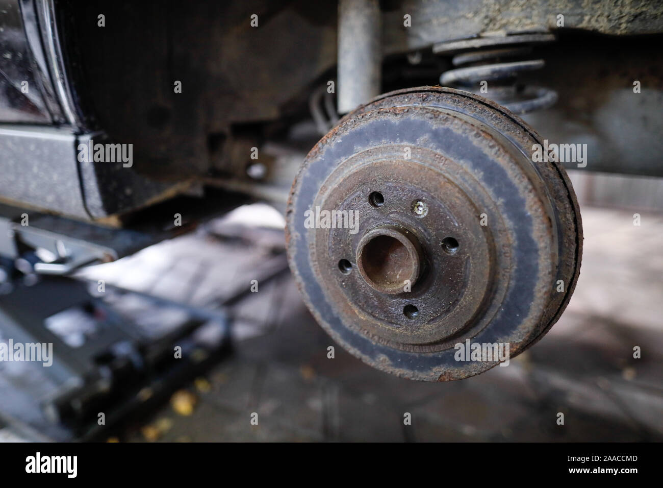 Flache Tiefenschärfe (selektive Fokus) Bild mit einer rostigen Radnabe hinten von einem alten Auto. Stockfoto