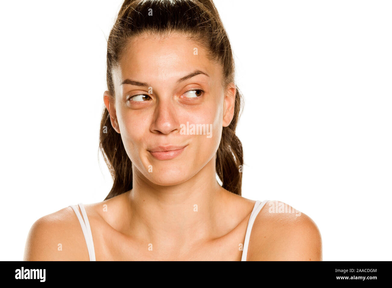 Junge lächelnde Frau ohne Make-up auf weißem Hintergrund zur Seite suchen Stockfoto