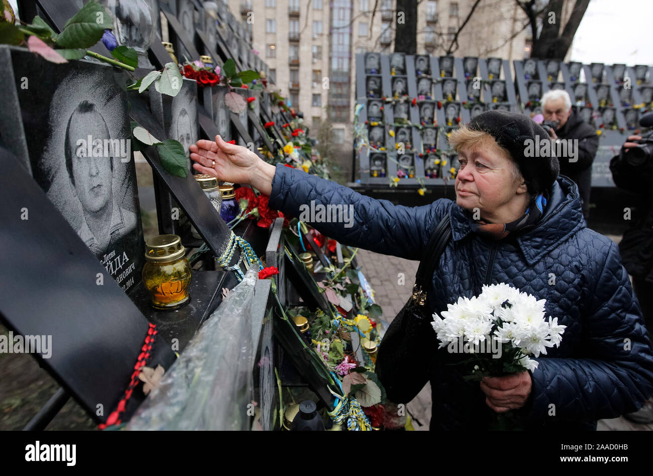 Hält eine Frau Blumen an der Gedenkstätte der Toten Maidan Aktivisten (Helden des Himmlischen Hundert) während der Jahrestag in Kiew Ukrainer Markierung der 6. Jahrestag der Beginn der Revolution der Würde oder der Euromaidan Revolution, in der mehr als hundert regierungsfeindlichen Demonstranten starben. Stockfoto