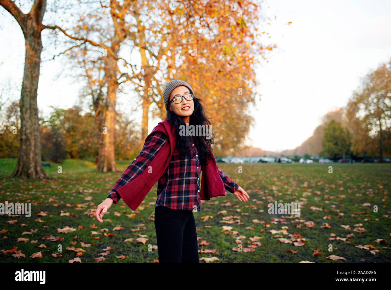 Fröhliche junge Asiatin dreht sich im Park um. RF Outdoor-Lifestyle mit herbstlichen Farben. November 2019 Stockfoto