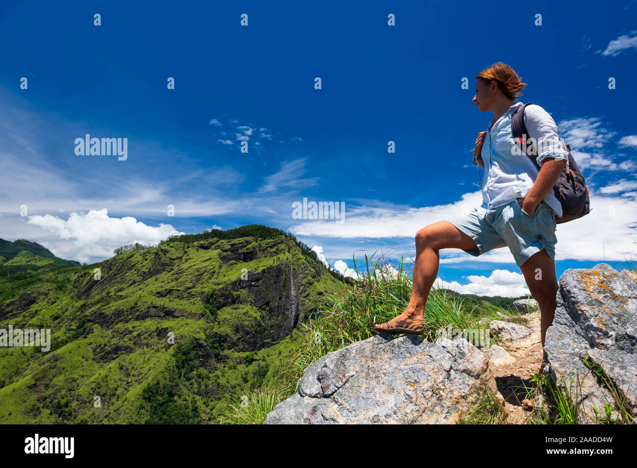 Frau genießen Sie einen wunderschönen Blick auf den wolkenverhangenen Himmel und Hügel von der Oberseite der kleinen Adams Peak in der Nähe von Ella, Sri Lanka. Tracking im Freien touristische Abenteuer. Stockfoto