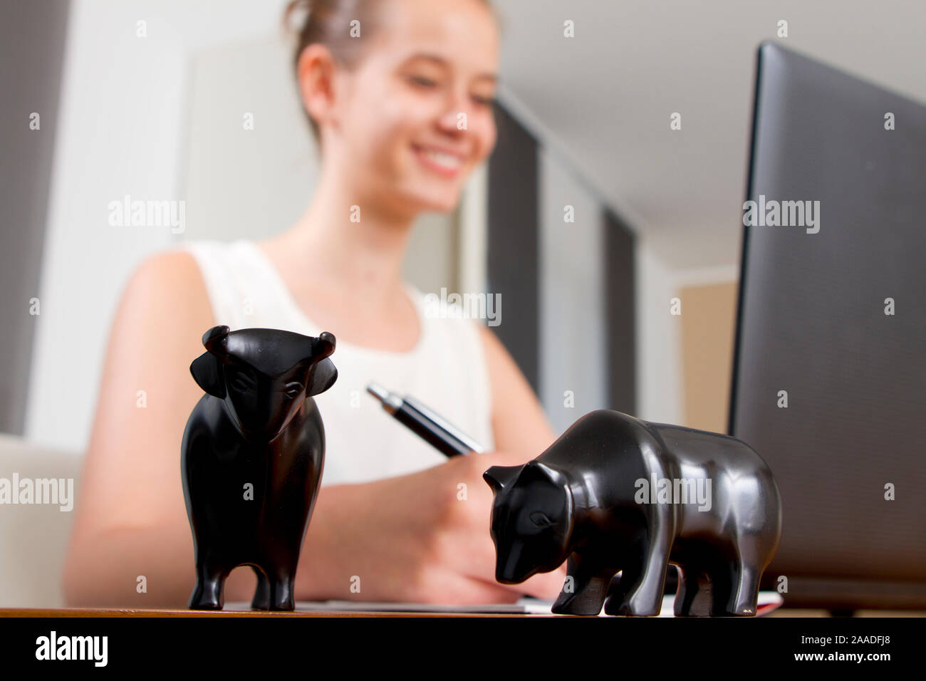 Junge Frau mit Börsensymbolen Bulle und Bär (mr) Stockfoto