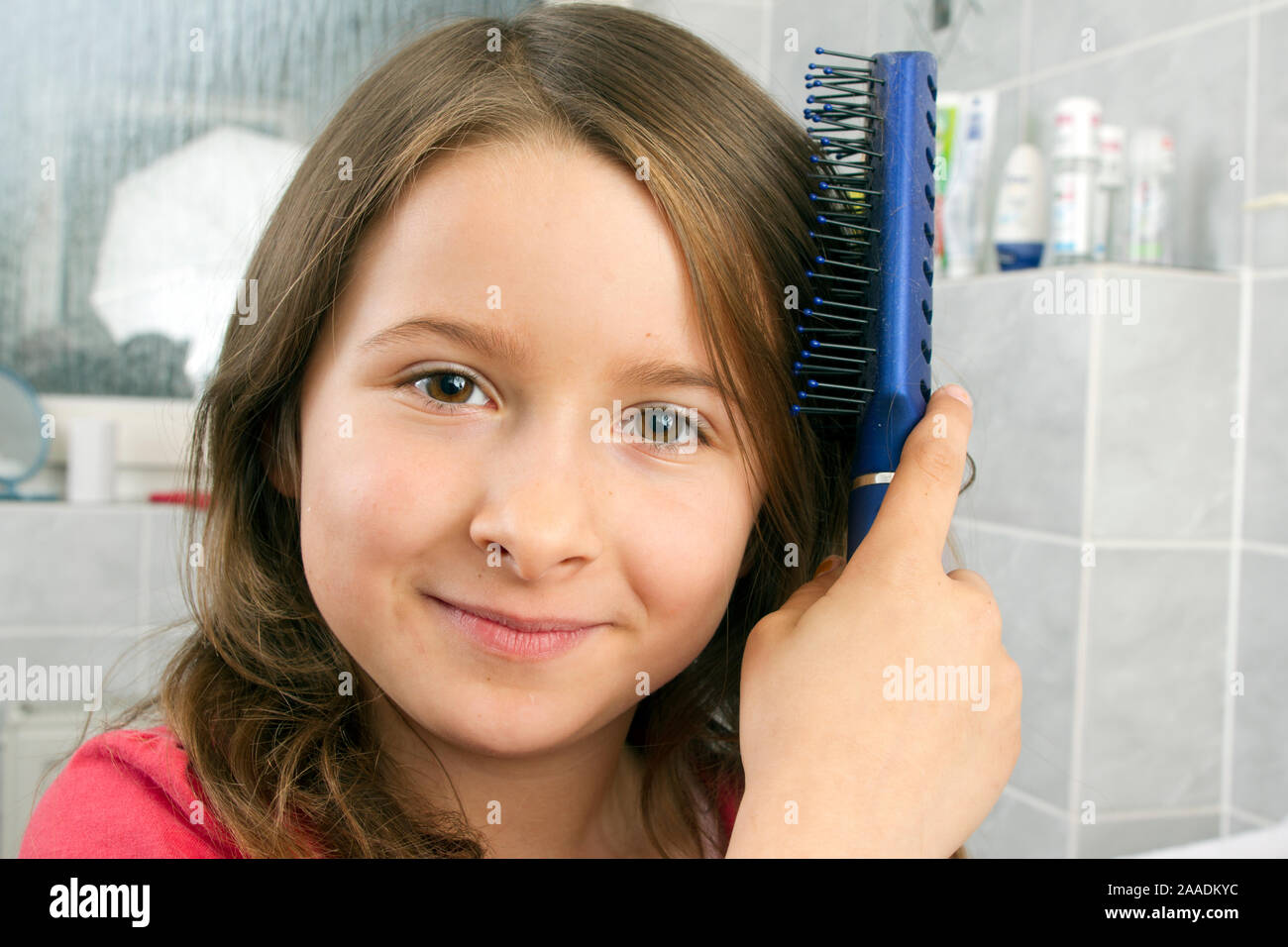 Achtjährige kämmt sich das Haar (pr) Stockfoto