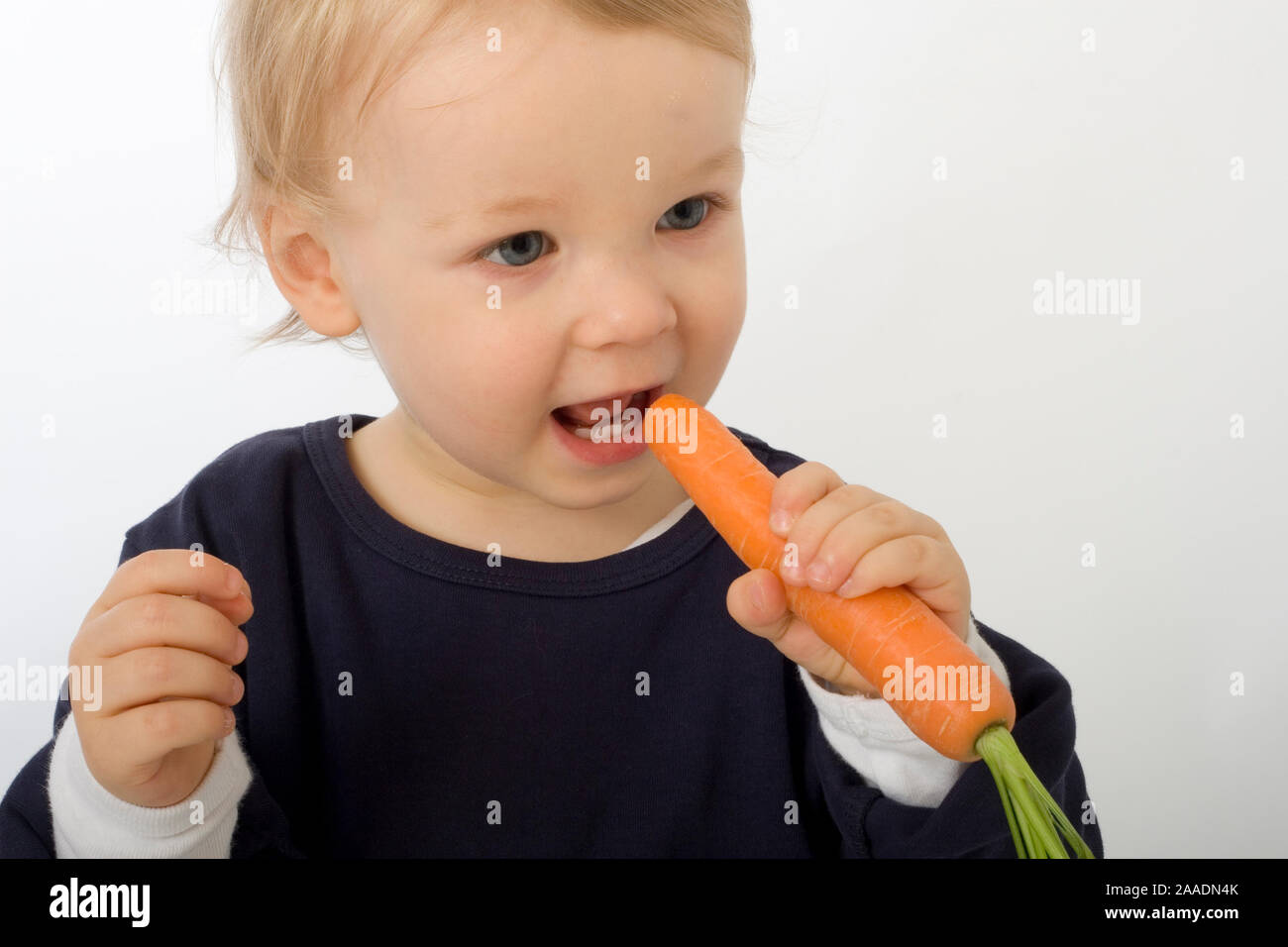Kleinkind isst Möhre (mr) Stockfoto