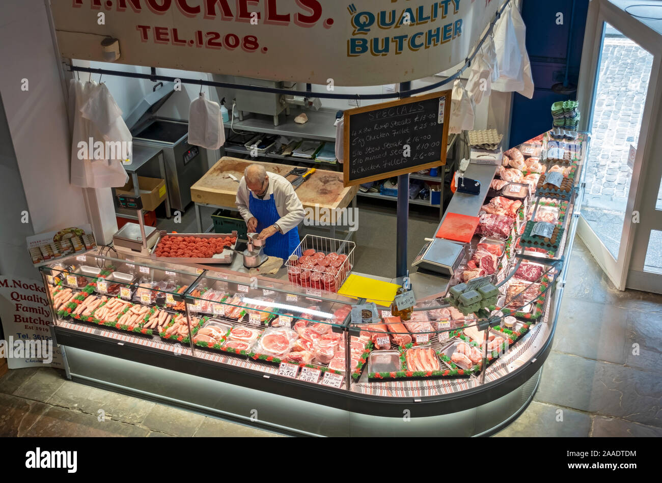 Metzger, der Fleisch-Burger an seinem Ladenstand in der Halle Markt von oben betrachtet Scarborough North Yorkshire England Großbritannien Großbritannien Stockfoto