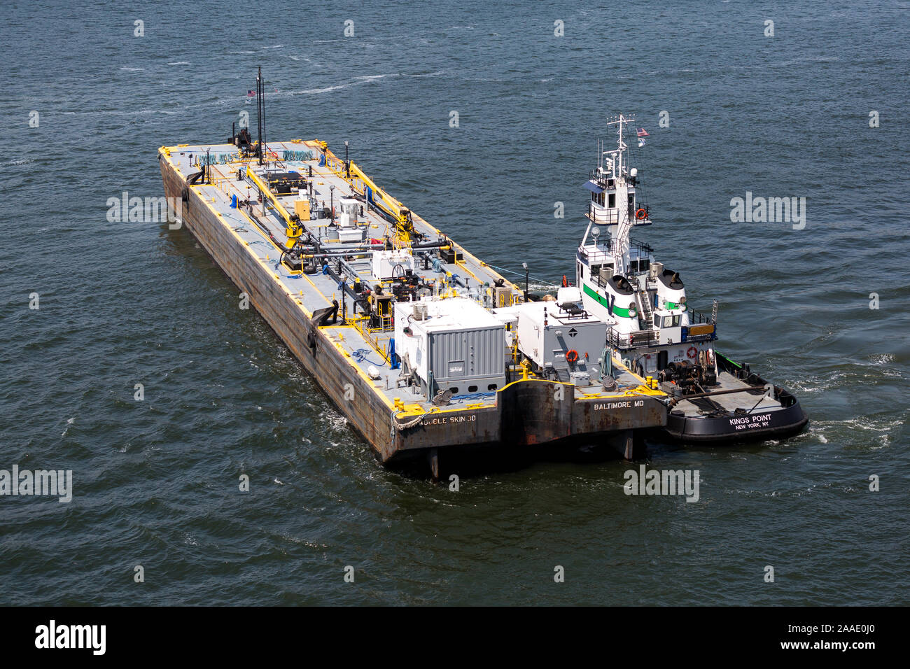 Ölbarge Bereitstellung "Bunker" (Kraftstoff für Schiffe Motoren) an die RMS Queen Mary 2 . (QM2) New York Harbor USA Stockfoto