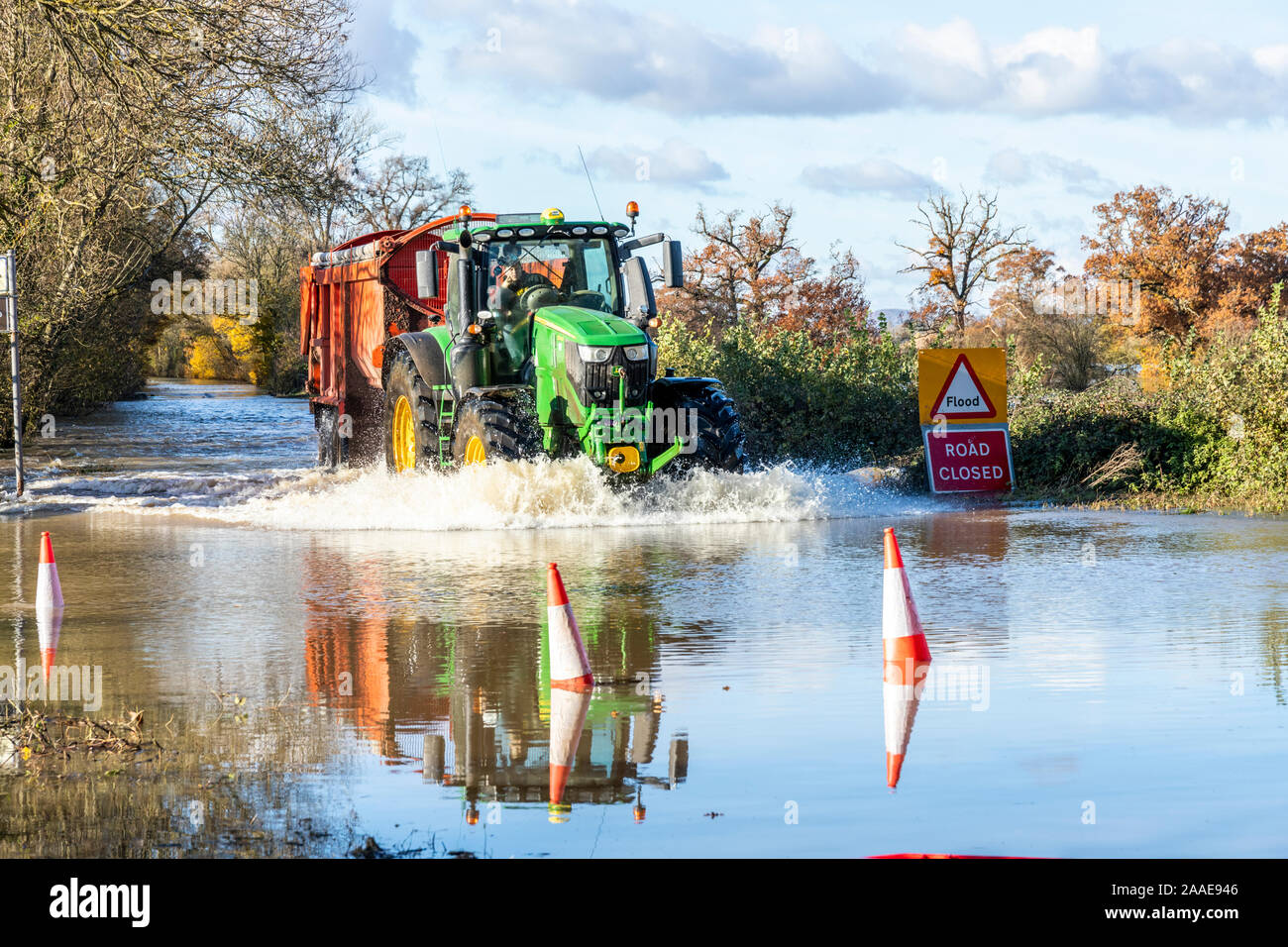 Ein Traktor seine Weise durch Hochwasser des Flusses Severn an der B4213 auf dem Ansatz der Haw-Brücke in der Nähe der Severn Vale Dorf Apperley, Stockfoto