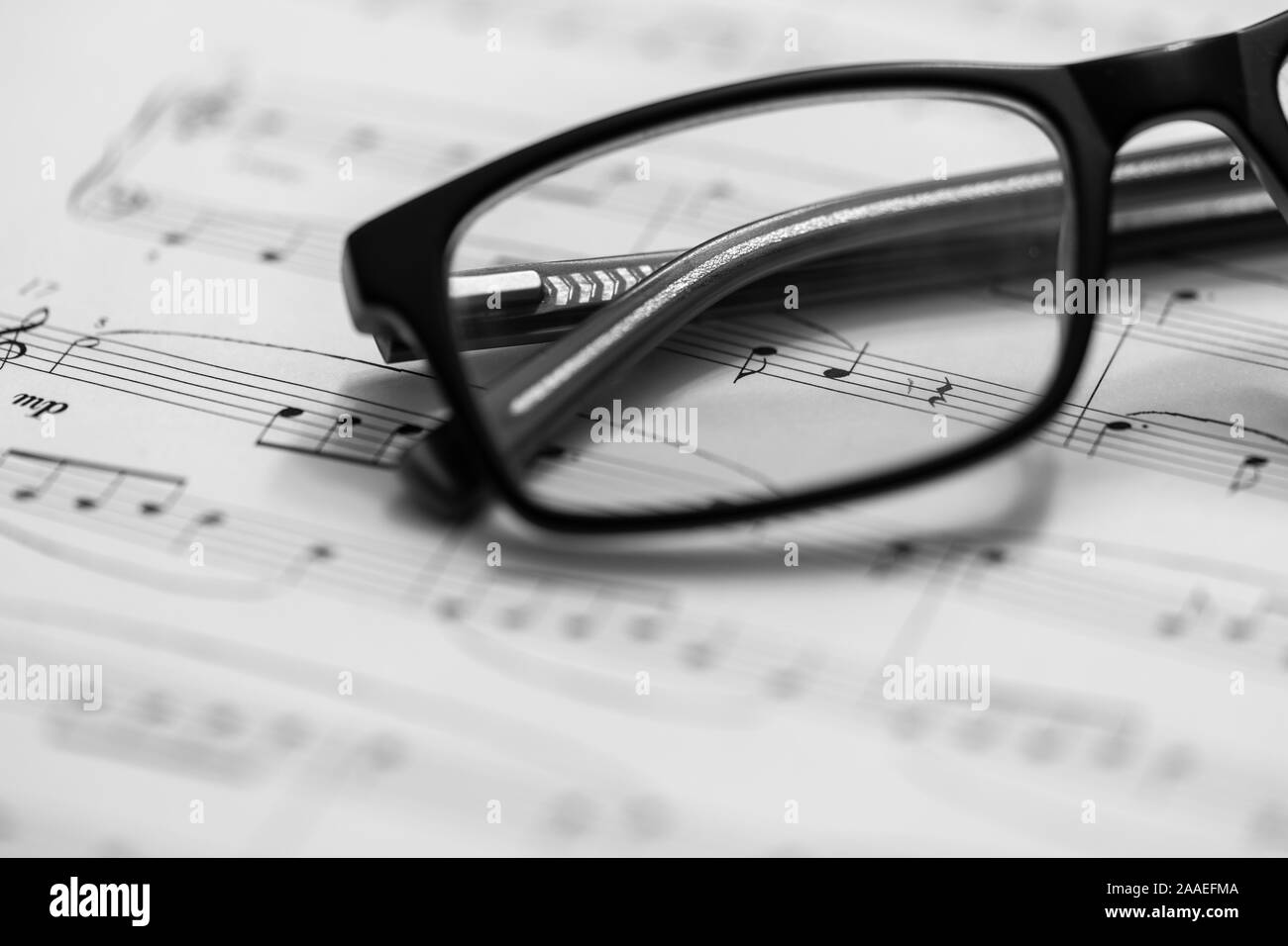 Nahaufnahme von Noten und Brillen. Musiknoten mit selektiven Fokus. Stockfoto