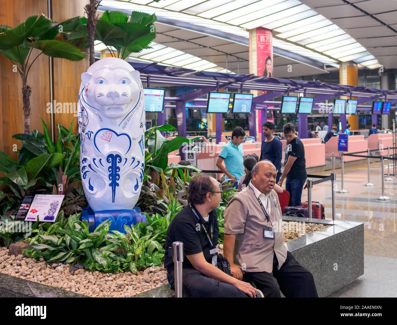 Singapur - 4 Oct 2019 - einem weissen Merlion Statue an der Abflughalle des Singapur Changi Airport Terminal 1 mit Check-in-Schaltern im Hintergrund. Stockfoto