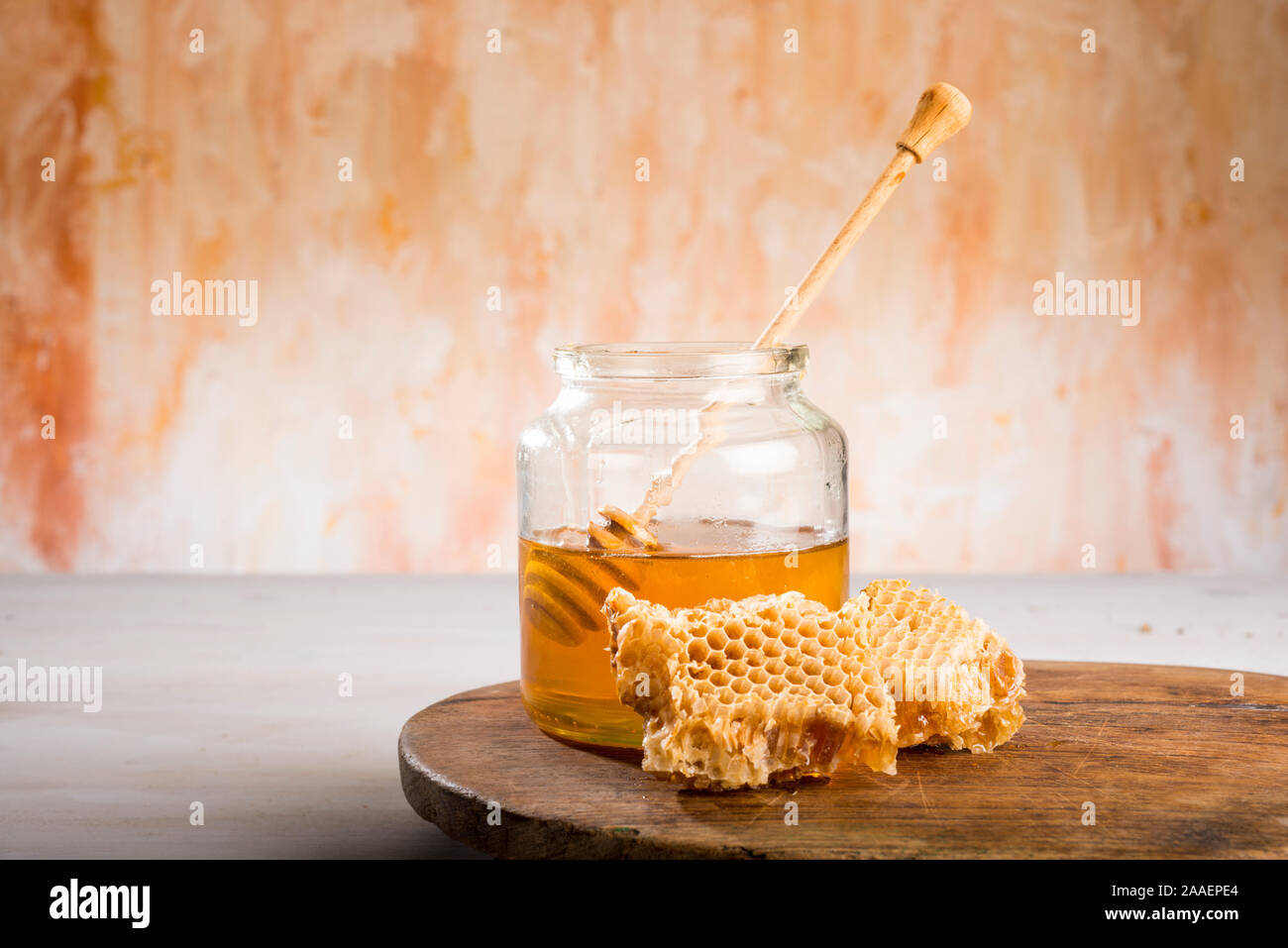 Honig und den Pendelarm in Glas Glas auf einem Holzboden Stockfoto