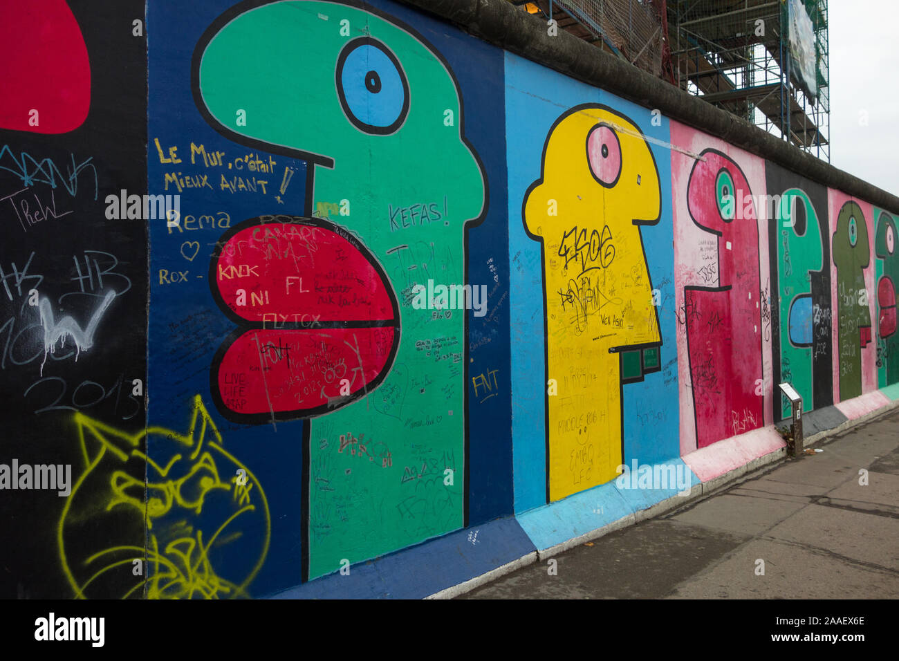 Street Art vom französischen Künstler Thierry Noir zeigt stilisierte Profil Köpfe auf der East Side Gallery, ein Überbleibsel der Berliner Mauer gemalt. Stockfoto