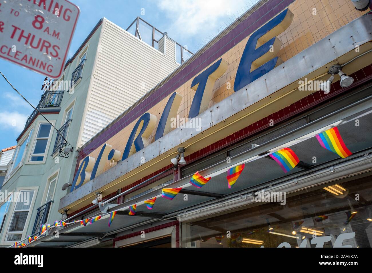 Fassade mit originalen Art déco-Stil in der ikonischen Bi Ritus 18 Street Market, ursprünglich im Jahr 1940 eröffnet, im Mission District von San Francisco, Kalifornien, USA, mit String von Rainbow LGBT pride Flags, 18. Juli 2019. () Stockfoto
