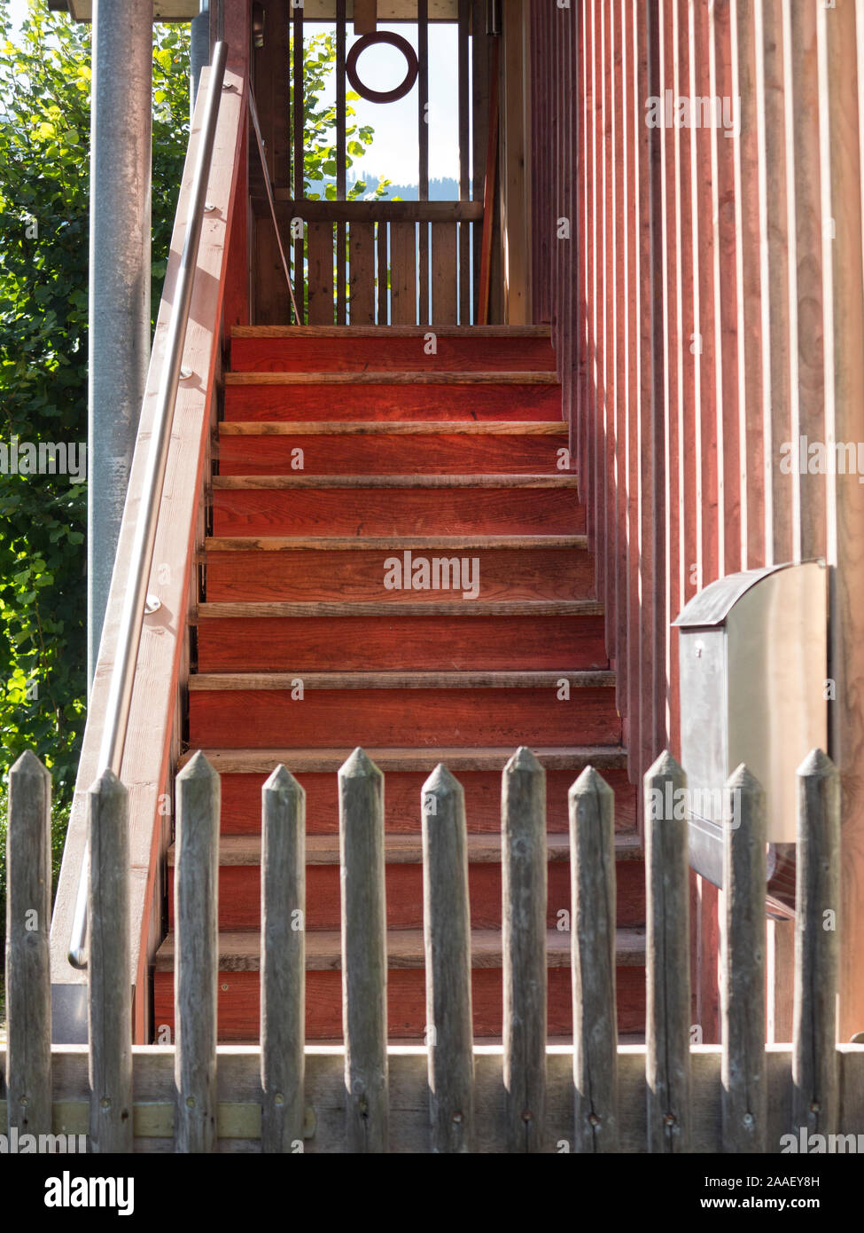Alte hölzerne Treppe hinter einem Zaun nach oben führenden Stockfoto