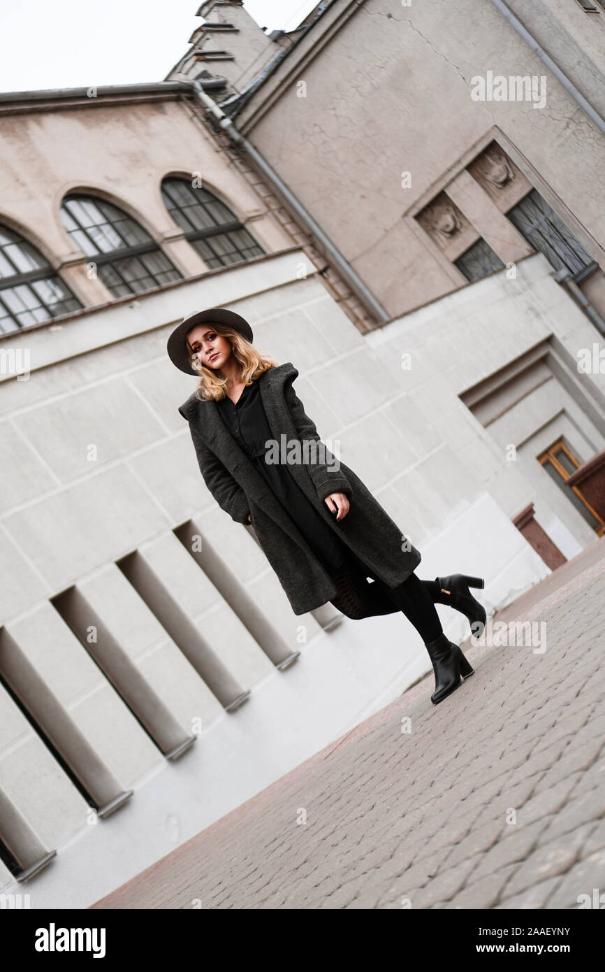 Junge Frau mit Hut, auf der Suche Seite in der Altstadt und für Fashion Shooting posieren, Europa Stockfoto