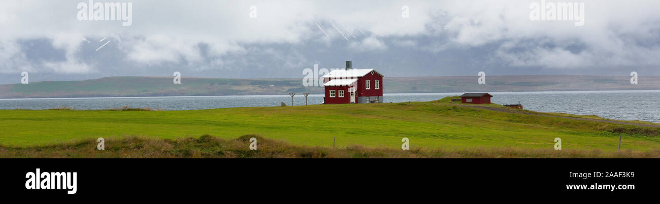 Ein einsames rotes Haus auf der Eyjafjordur Fjord im Norden von Island Stockfoto