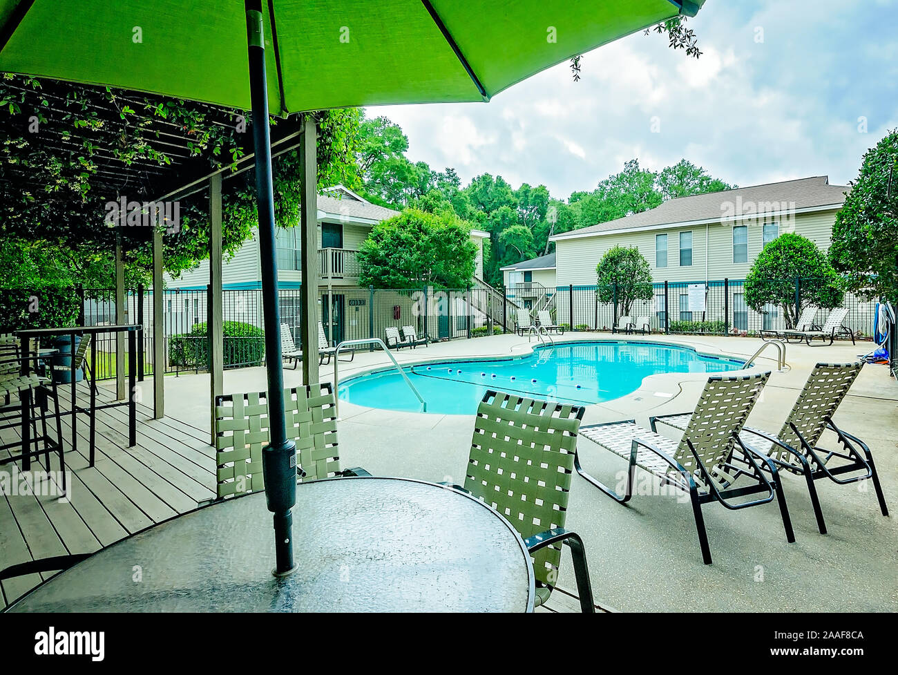 Der Pool verfügt über einen Sitzbereich im Freien mit einer Pergola auf Robinwood Apartments in Mobile, Alabama. Stockfoto