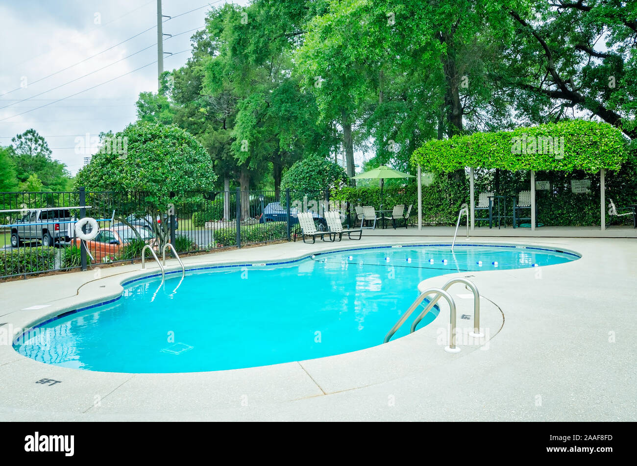 Der Pool verfügt über einen Sitzbereich im Freien mit einer Pergola auf Robinwood Apartments in Mobile, Alabama. Stockfoto