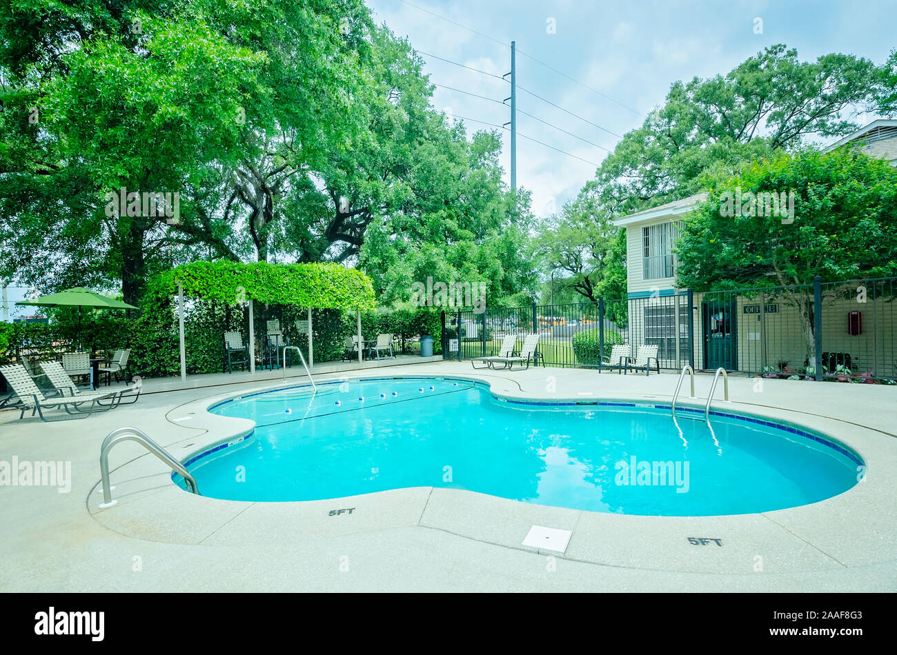 Der Pool verfügt über einen Sitzbereich im Freien mit einer Pergola auf Robinwood Apartments in Mobile, Alabama. Stockfoto