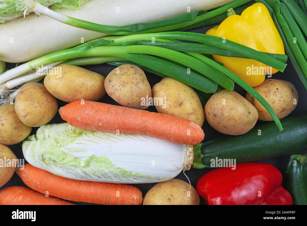 Blick von oben auf die Mischung aus verschiedenen rohes Gemüse wie Frühlingszwiebeln, Kartoffeln, Möhren, Paprika und Zucchini Stockfoto