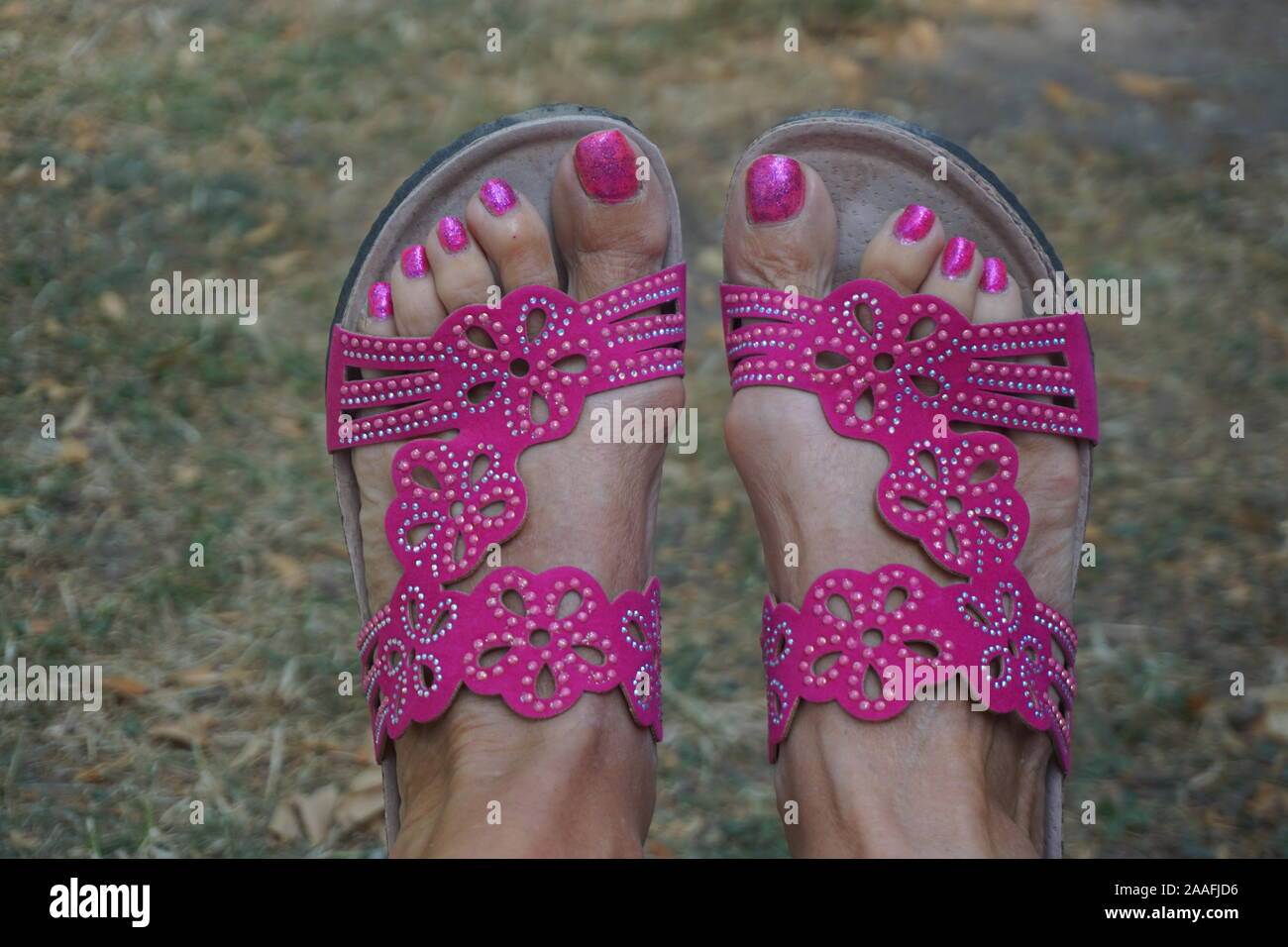 Nahaufnahme von Happy pink Poupine die Zehennägel und funkelnden rosa Schuhe Stockfoto