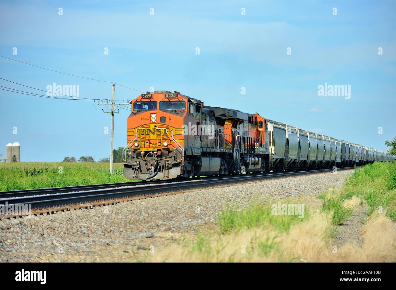 Sandwich, Illinois, USA. Ein Burlington Northern Santa Fe Güterzug, geführt von zwei Lokomotiven, die durch das Bauernland fuhren. Stockfoto