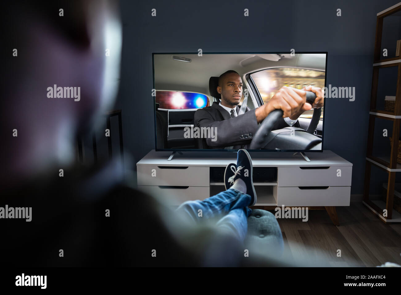 Afrikanischer Mann auf Sofa mit Fernbedienung In der Hand Stockfoto