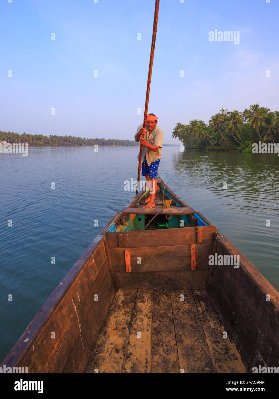 Ein bootsmann treibt sein Boot mit einem Bambus oar in der ruhigen Suvarna River (Udupi, Karnataka, Indien) Stockfoto