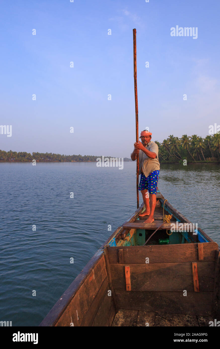 Ein bootsmann treibt sein Boot mit einem Bambus oar in der ruhigen Suvarna River (Udupi, Karnataka, Indien) Stockfoto