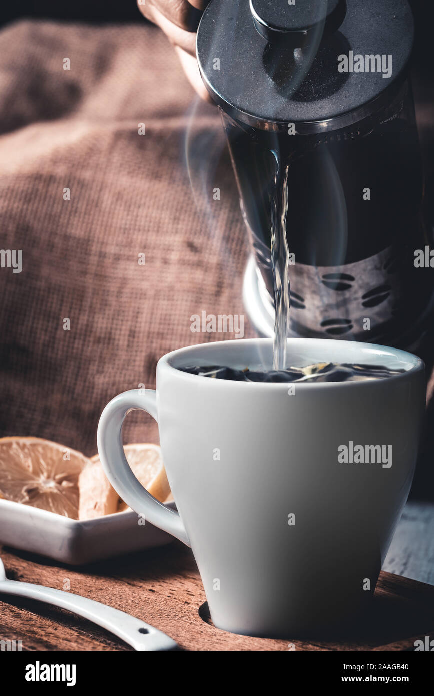 Strömenden heißen Kräutertee in weiße Krug Stockfoto