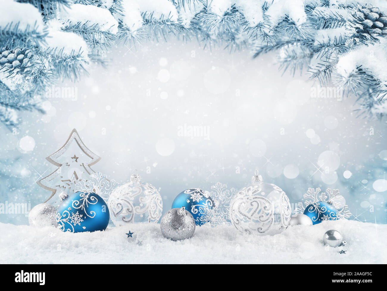 Frohe Weihnachten Hintergrund. Blue christmas Bälle und Kugeln und Holz- dekorative Baum auf dem Schnee mit Tannenzweigen. Mixed Media. Stockfoto