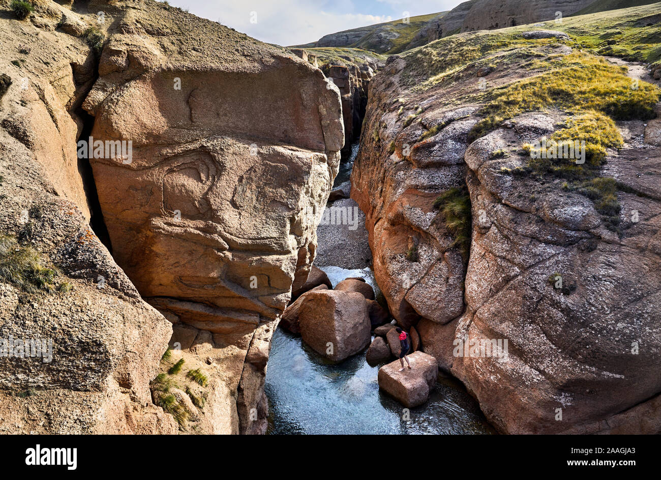 Kleiner Mann auf dem Felsen in den Canyon mit Fluss in der naryn Region, Kirgisistan Stockfoto