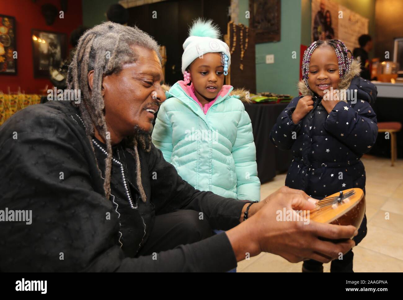 Milwaukee, Wisconsin, USA. 26 Dez, 2018. Minister O 'DANIELS spielt eine Finger Instrument, die Kalimba, für DYANI RADDLE (links) und BRELYNN MCMILLION beide 3 Jahre alt, an der Wisconsin Schwarz historische Gesellschaft vor Beginn der 30. jährlichen Kwanzaa Kwanzaa feiern. 30. jährlichen Feier an der Wisconsin Historical Society 2620 W. Centre Street in Milwaukee Wisconsin Mittwoch, 26 Dezember, 2018. Credit: Pat A. Robinson/ZUMA Draht/Alamy leben Nachrichten Stockfoto