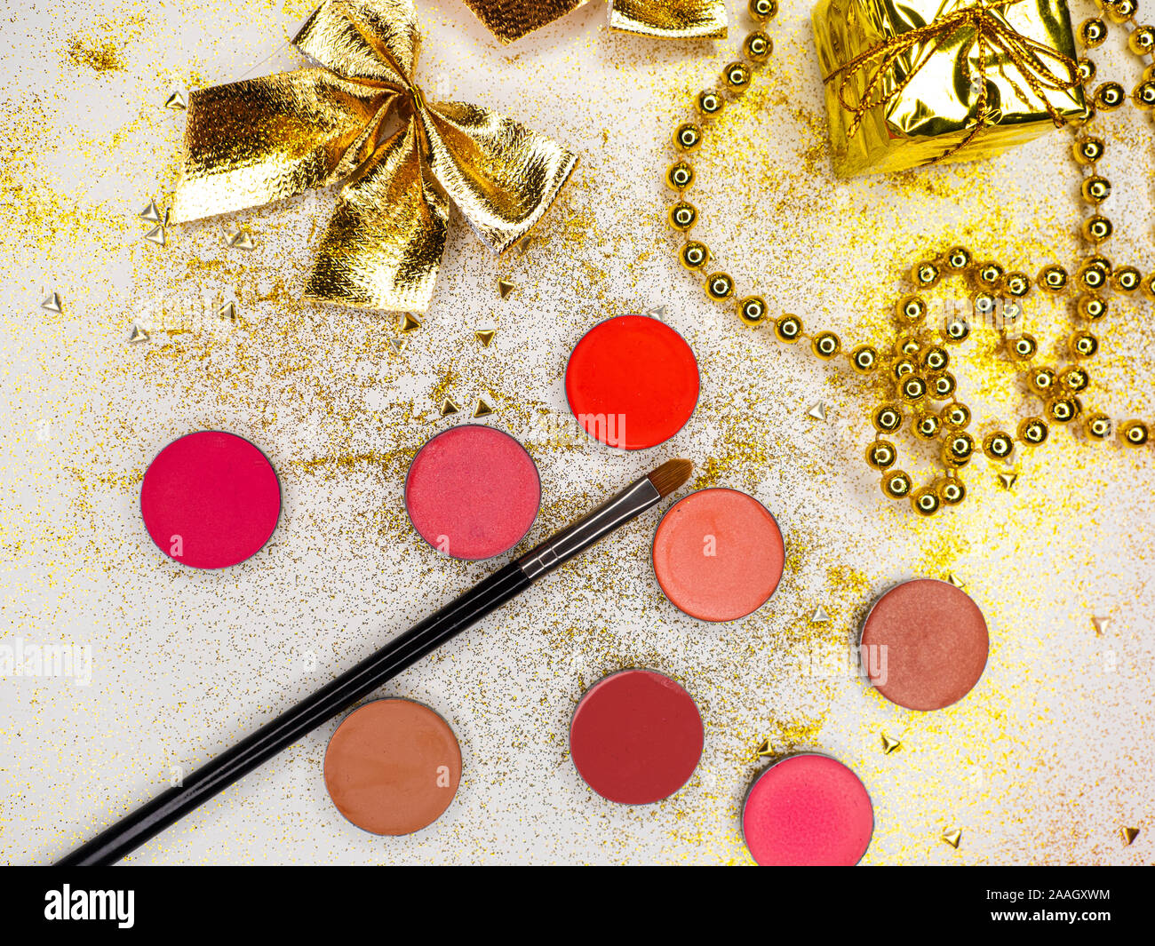 Make-up für Neujahrs-Weihnachtsfeier, Makeup Set. Festliche Neujahrswohnung lag. Golddekor auf weißem Hintergrund. Verschiedene Farbtöne von cremefarbendem Lippenstift. Stockfoto