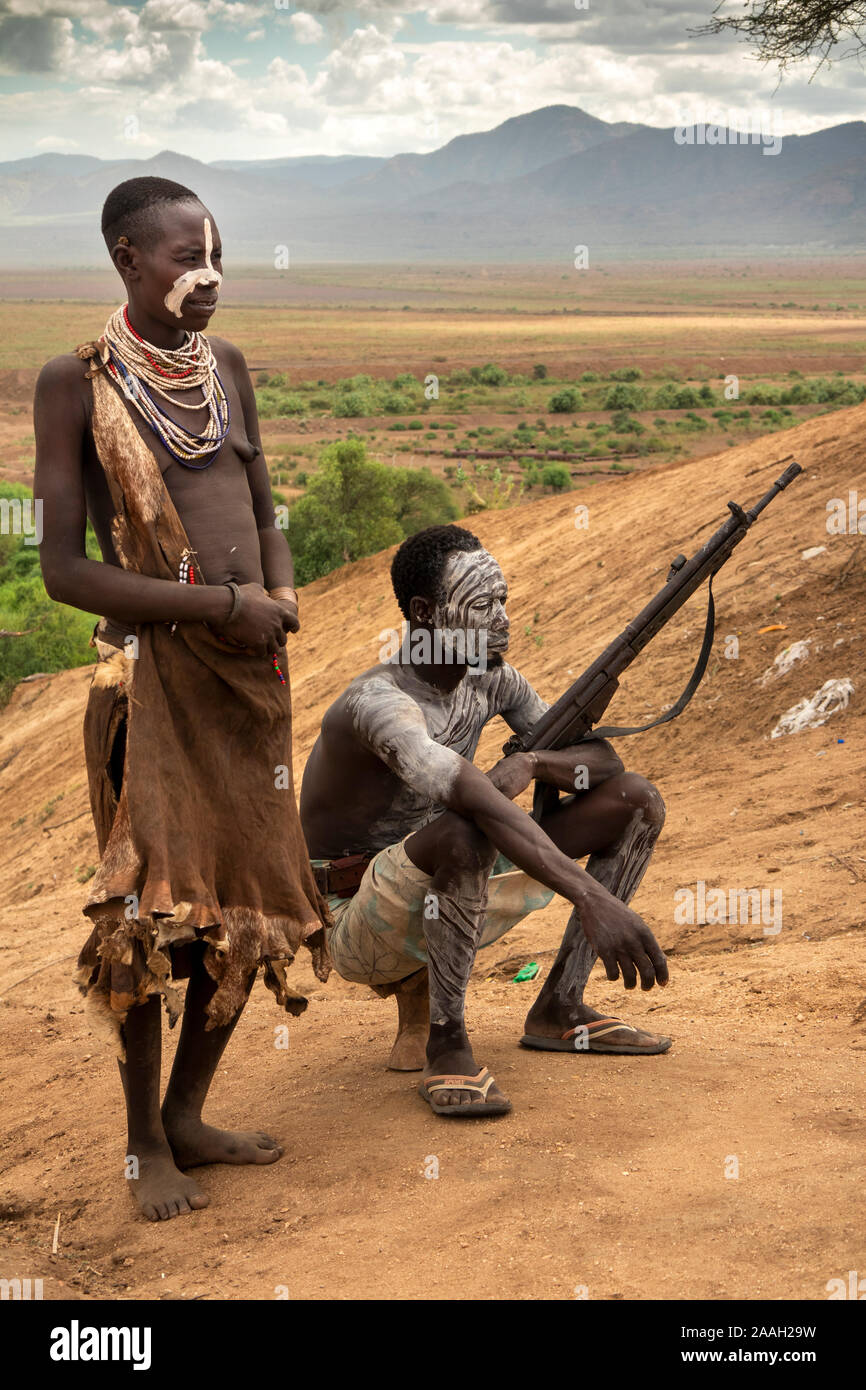 Äthiopien, South Omo, Kolcho Dorf, Karo Stammes- Mann, Repetierbüchse, mit Frau mit weißen Schlamm eingerichtet, über Omo Fluss Stockfoto
